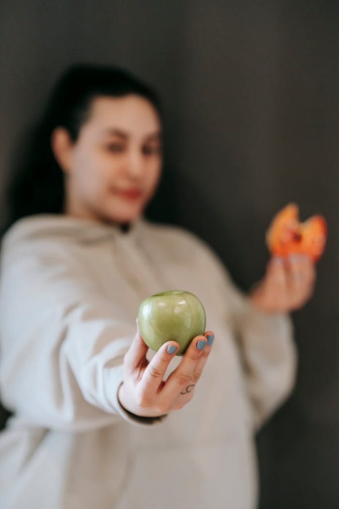 Crafting Captivating Headlines: Your awesome post title goes here Blurred female in casual wear choosing between ripe green apple and sweet donut and showing apple to camera